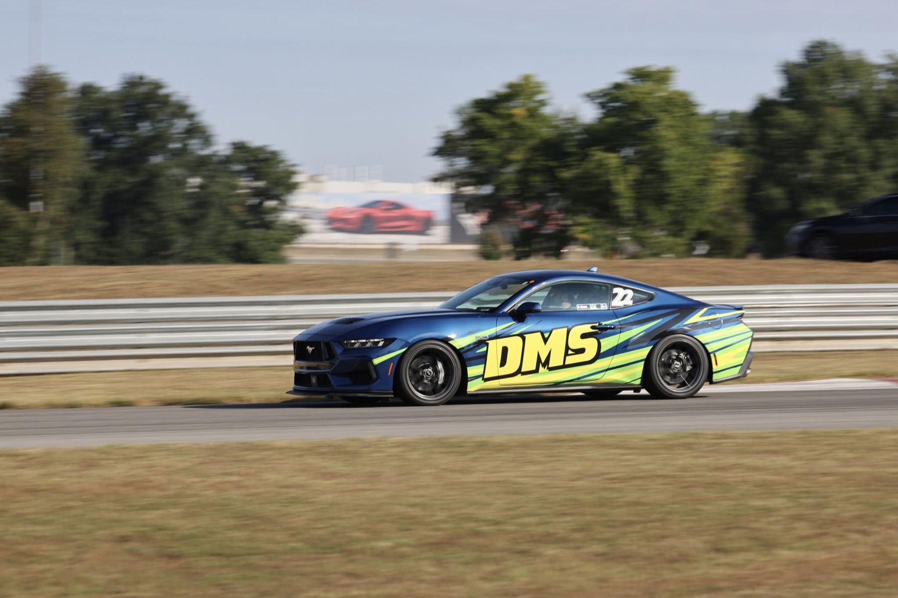 Dave's blue DMS Mustang racing on a track