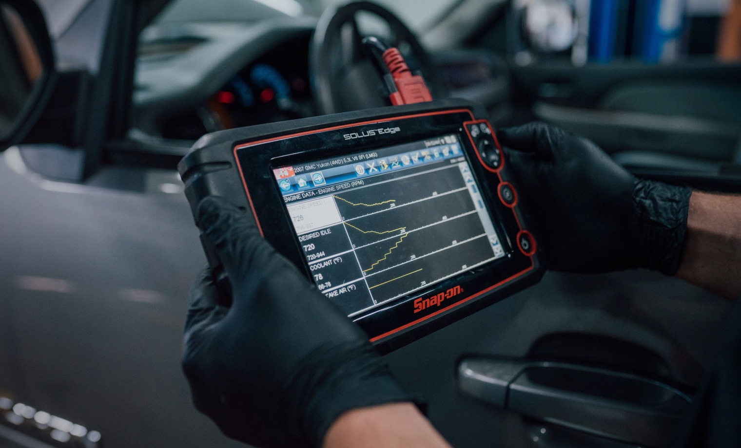 DMS technician reading live engine data on a diagnostic scan tool
