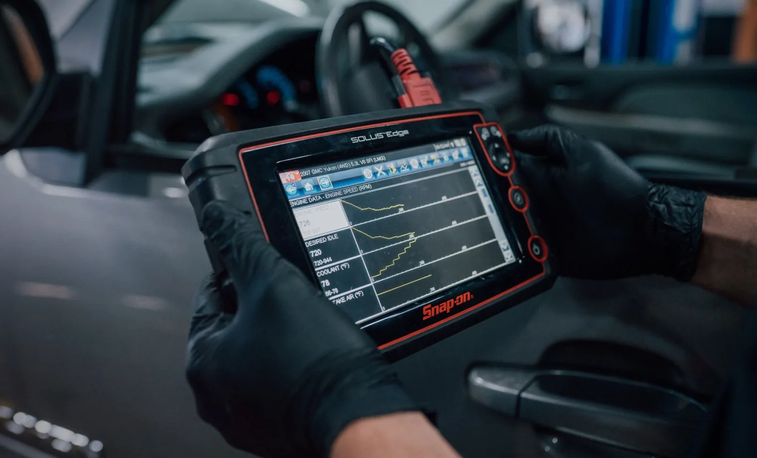 DMS technician reading live engine data on a diagnostic scan tool